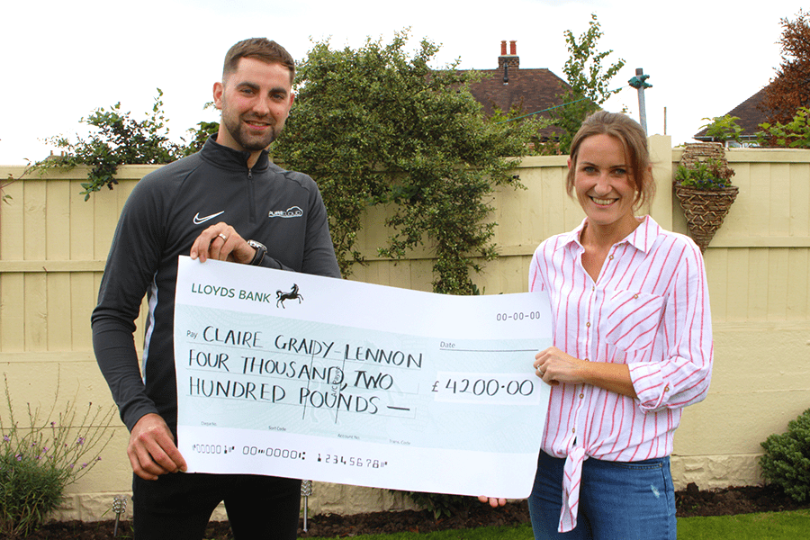 Jamie Lake standing next to Claire Grdy-Lennon while both holding a cheque